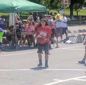 young women playing basketball on an outdoor court