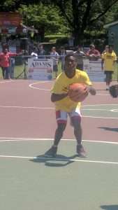 young men playing basketball on an outdoor court