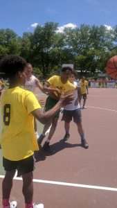 young men playing basketball on an outdoor court