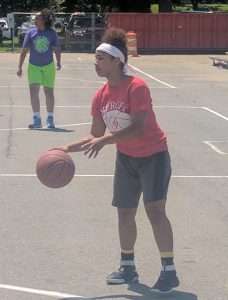 young women playing basketball on an outdoor court