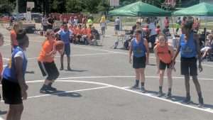 young women playing basketball on an outdoor court