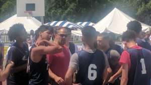 young men playing basketball on an outdoor court