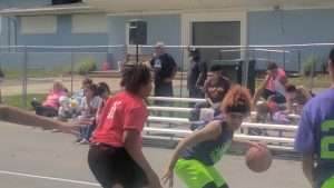 young men playing basketball on an outdoor court