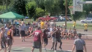young men playing basketball on an outdoor court