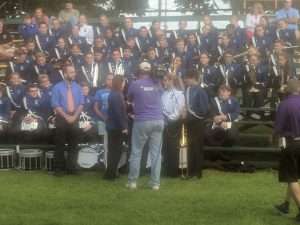 band coach talking to band in stadium seats