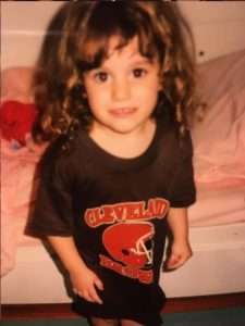 little girl wearing a Cleveland browns oversized shirt