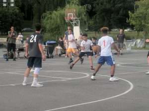 young men playing basketball outside