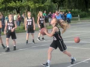 young women playing basketball outside