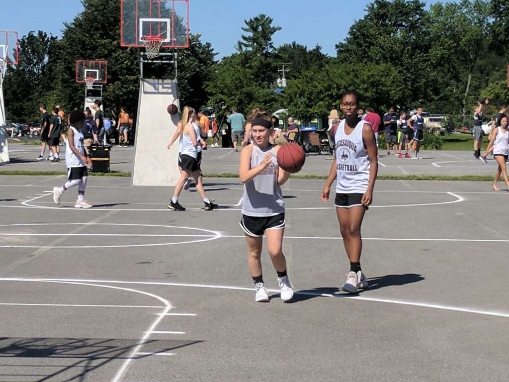 action image of a high school women's outdoor basketball game