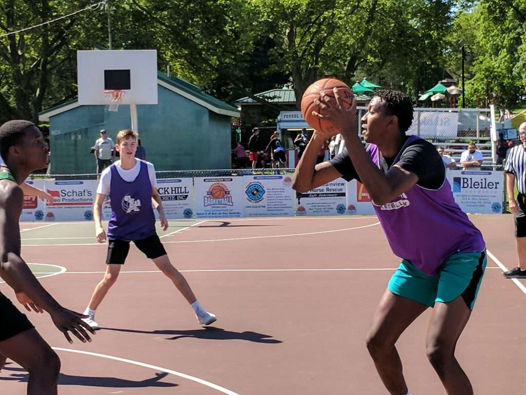 action image of a high school men's outdoor basketball game