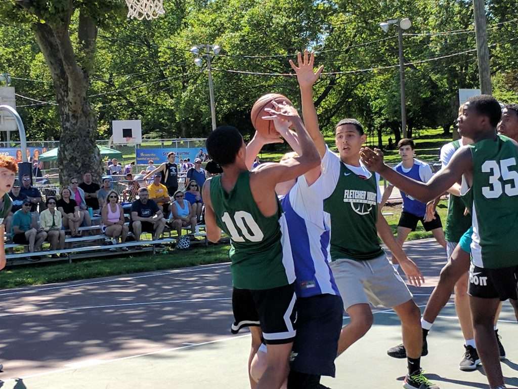 action image of a high school men's outdoor basketball game