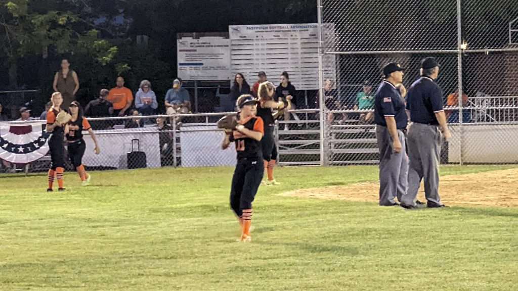 action shot of girl throwing ball at softball game