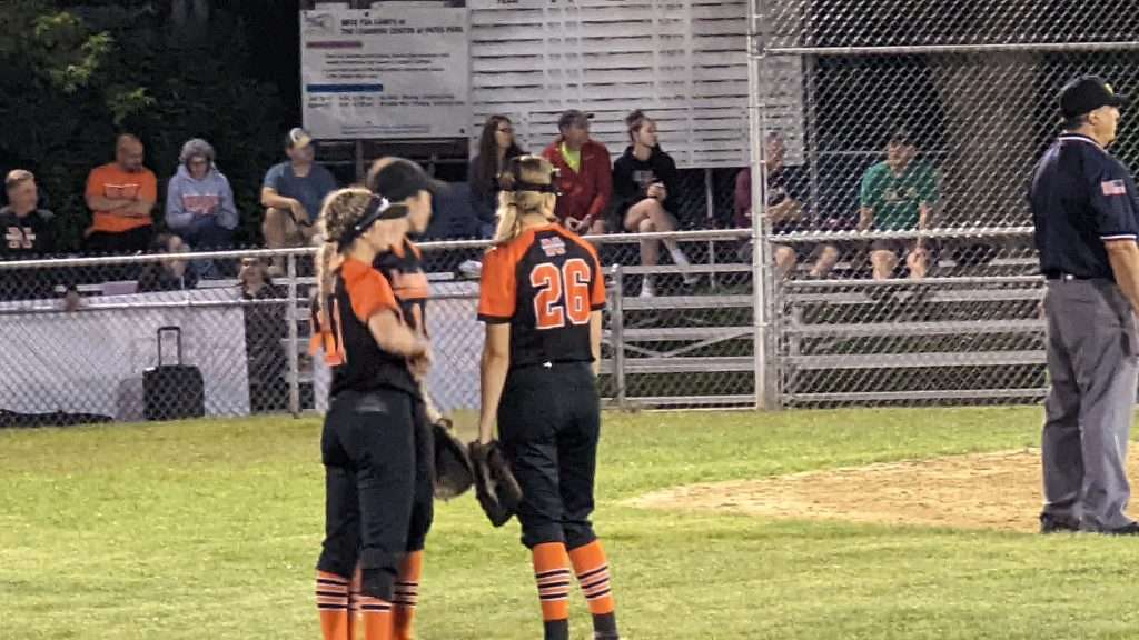 action shot of a huddle at high school softball game