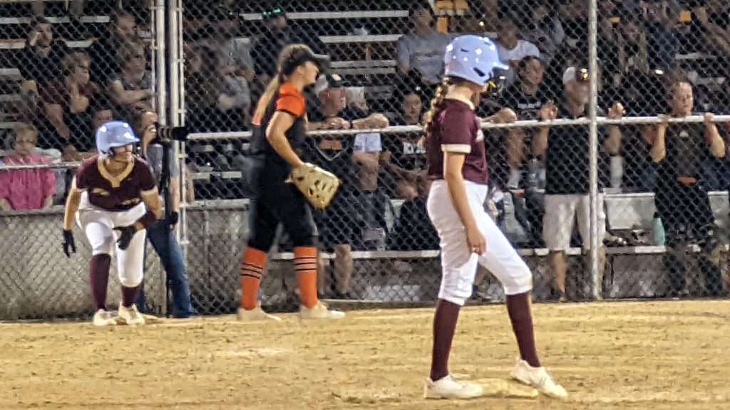 action shot of girl running bases at high school softball game