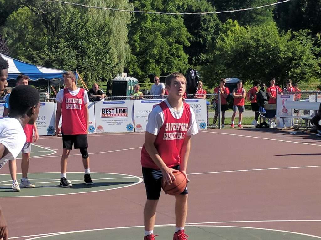 action image of a high school boy shooting a free throw at an outdoor basketball game