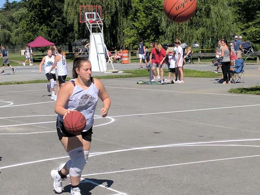 action image of a high school outdoor women's basketball game
