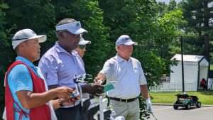 4 men waiting for their turn to golf