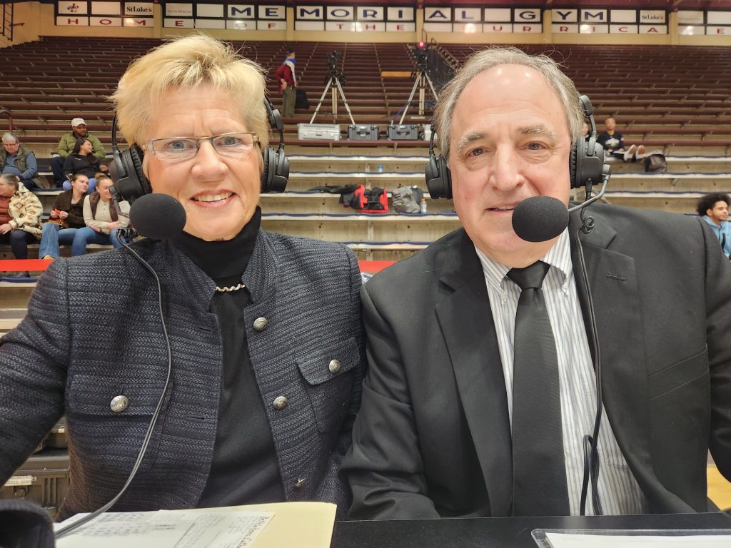one middle aged woman and one middle aged man sport announcer smiling at camera