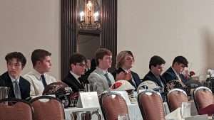 high school football students sitting at 2023 football scholar night