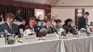 high school football students sitting at 2023 football scholar night