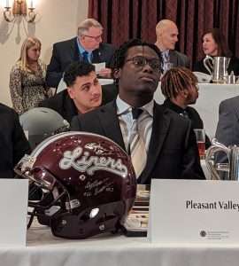 high school football students sitting at 2023 football scholar night