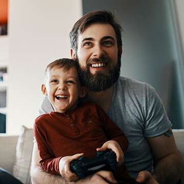 Father with son in lap playing video games