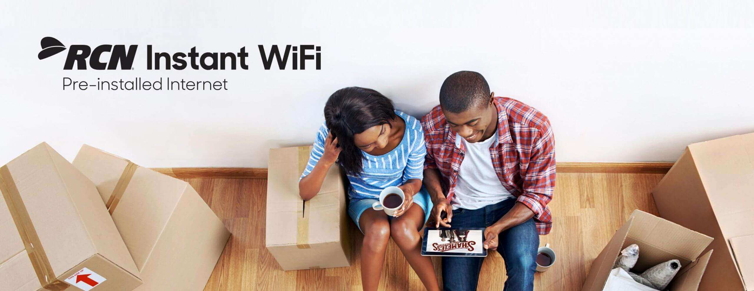 couple looking at tablet with moving boxes