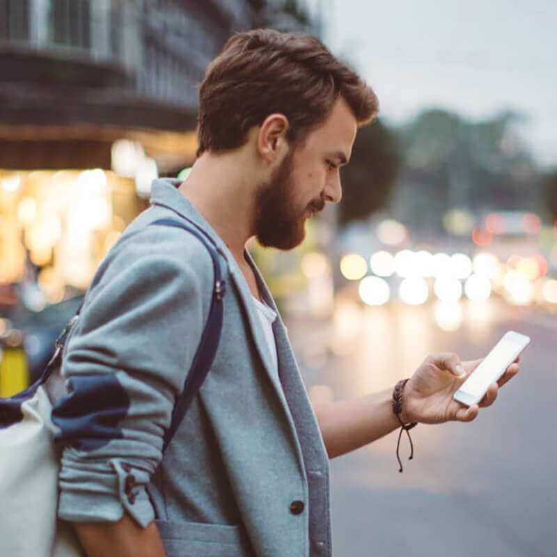 a guy in the city on his smart phone