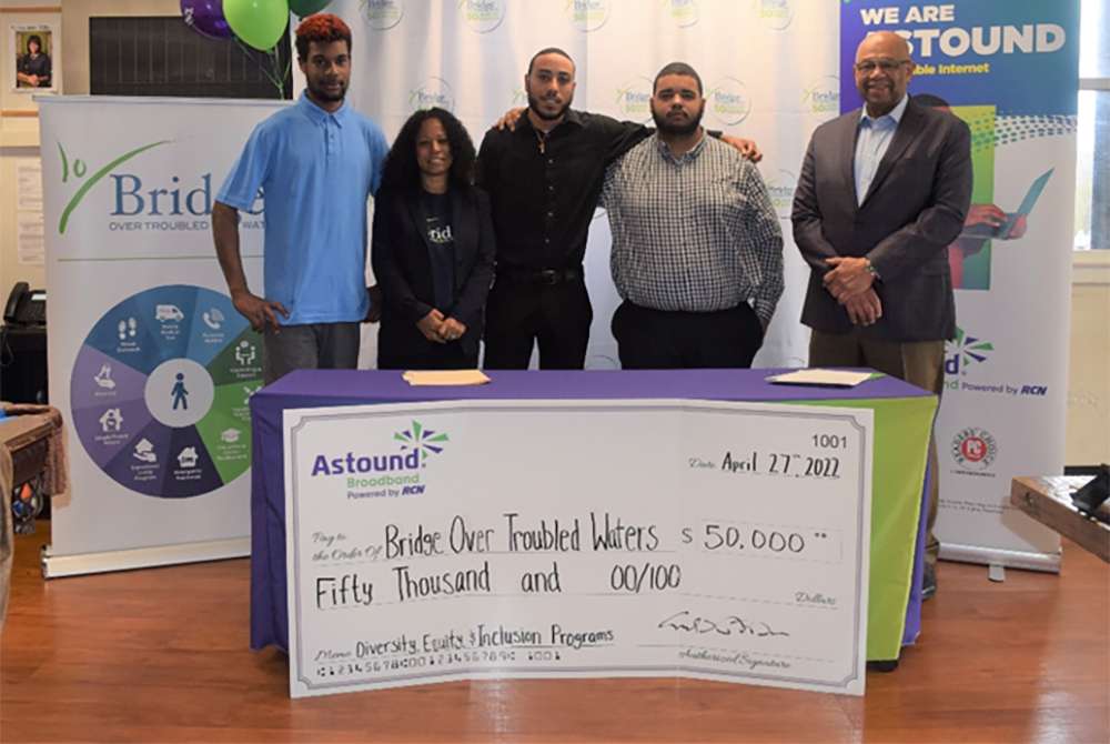 astound handing a giant check to Bridge over troubled waters