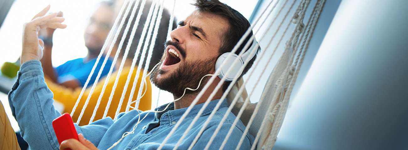 Man sings along enthusiastically while streaming music on his phone