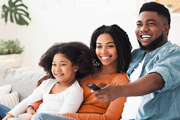 African American mom, dad and daughter watch together online
