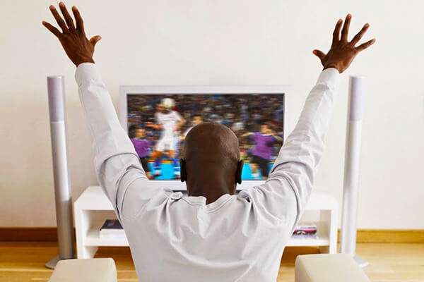 Man cheers watching sports on TV