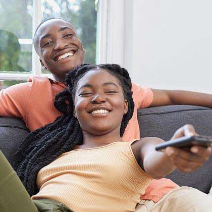 Couple watches TV with remote