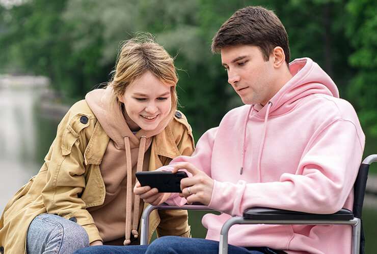 Couple looks at mobile phone outdoors
