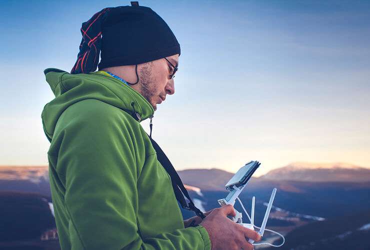 Man operates drone with mobile phone