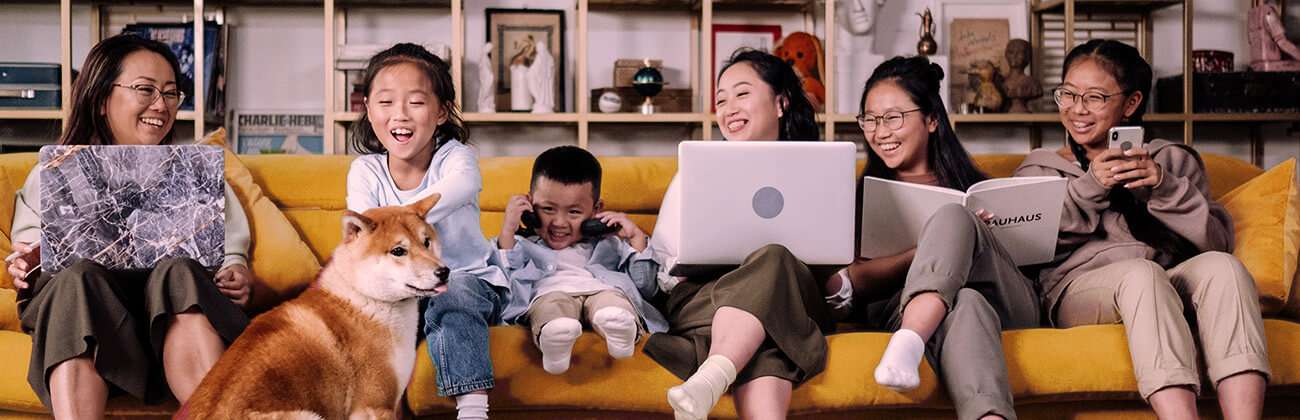 Family on sofa with many devices