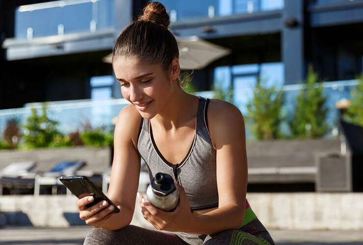 Woman in workout gear checks cell phone