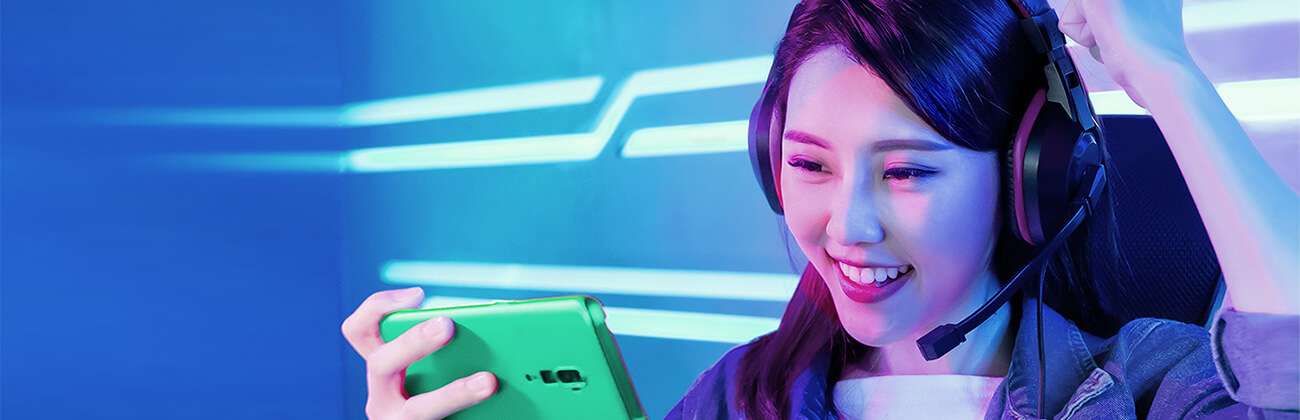 Asian girl gaming on her phone with headphones