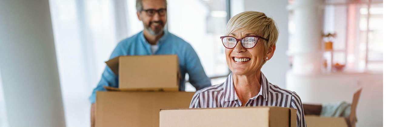 A couple moves boxes in their new house