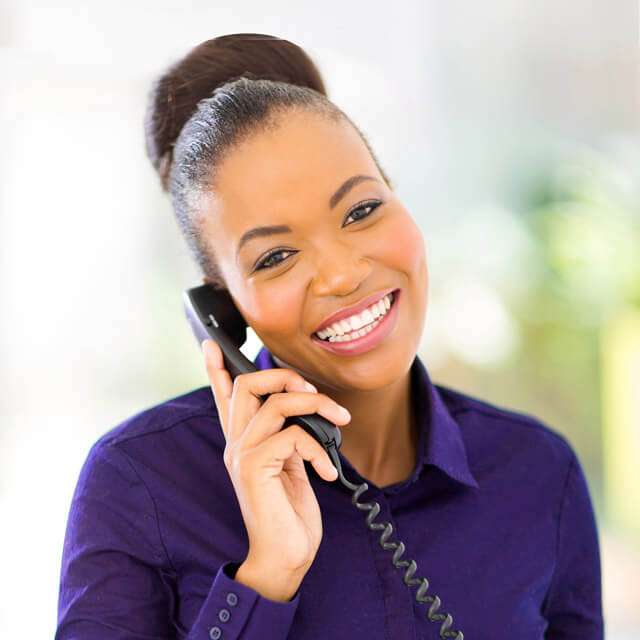 Smiling African American woman answers a phone