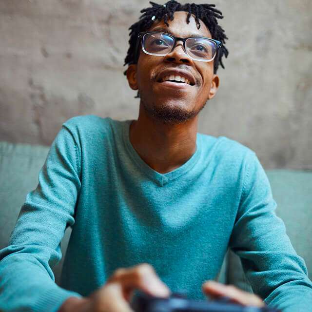 Young African American guy smailes while gaming