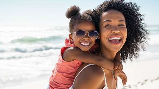 Mom and daughter romp in the surf for the Summer Entertainment Guide