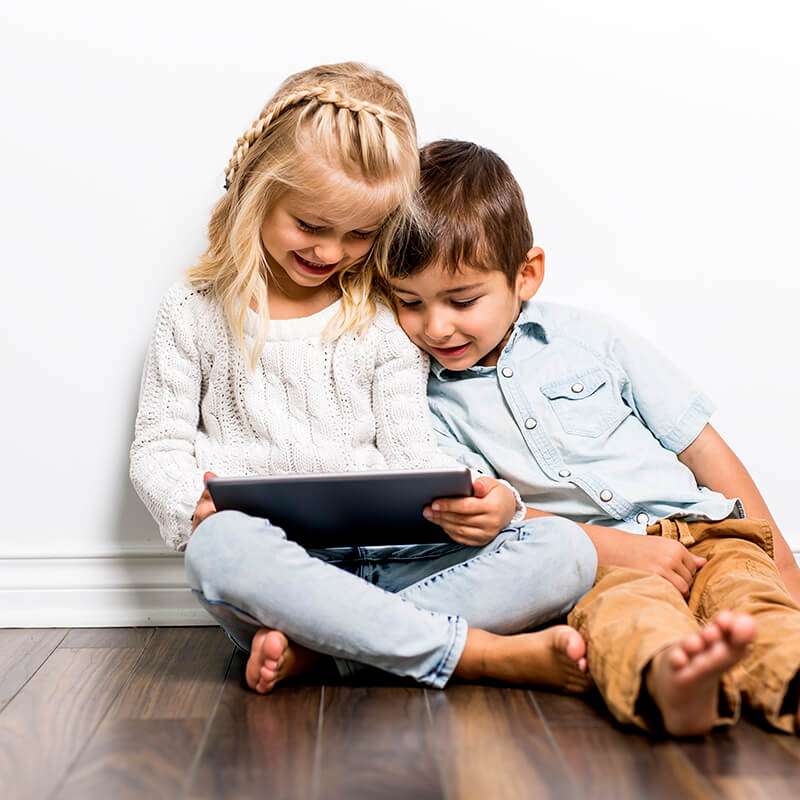Happy siblings child playing with tablet together