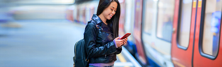 Asian woman in metro station using mobile device