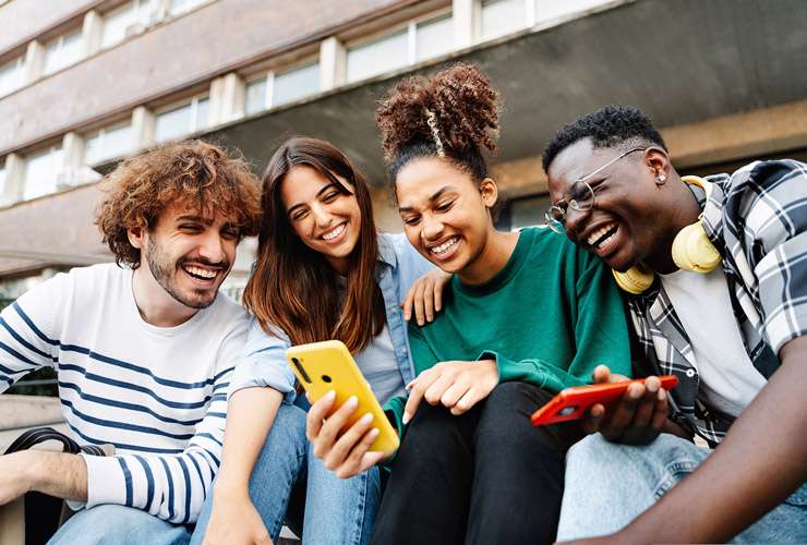 Multicultural group of young friends checking out their mobile phones