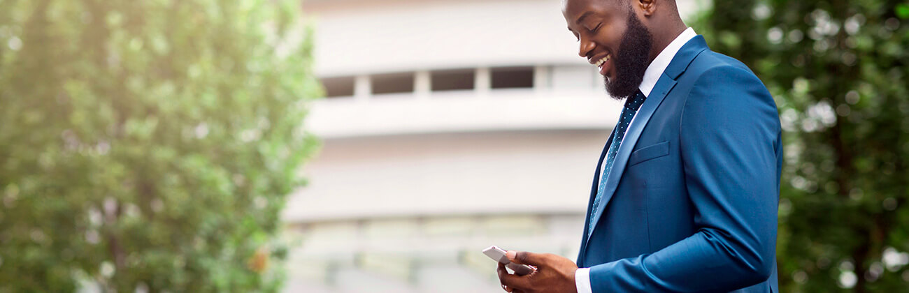 Bearded African man in stylish suit selects a phone upgrade