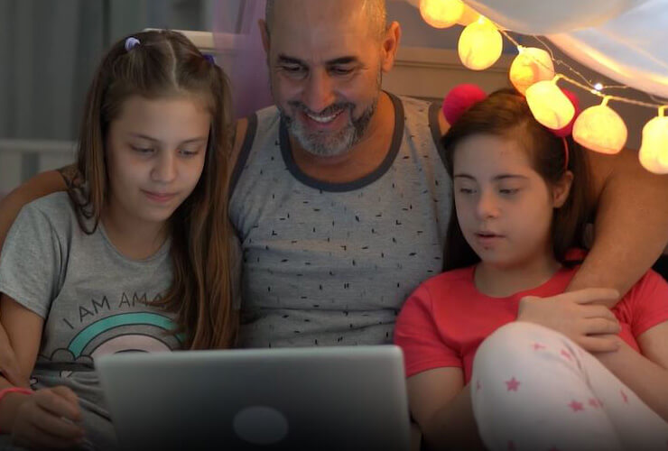 dad and daughters watching scary movie on laptop