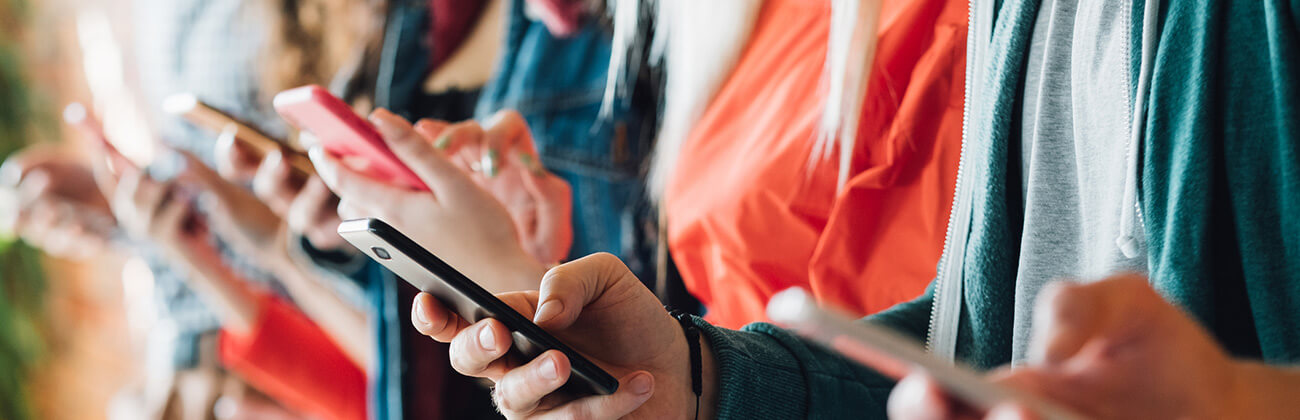 Row of mobile users in high density usage area illustrates on of the reasons to temporarily switch to using cellular data.