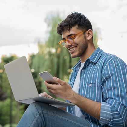 Man tethers laptop to his mobile phone to get internet connection outdoors