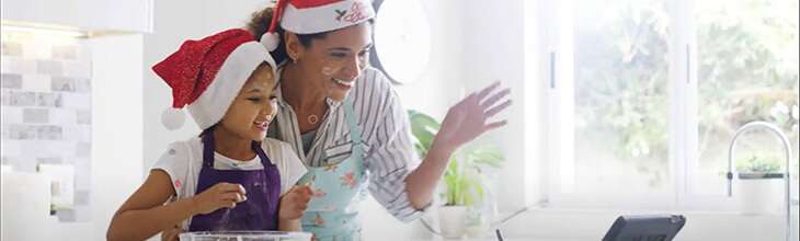 Mom and daughter in holiday hats on a virtual call